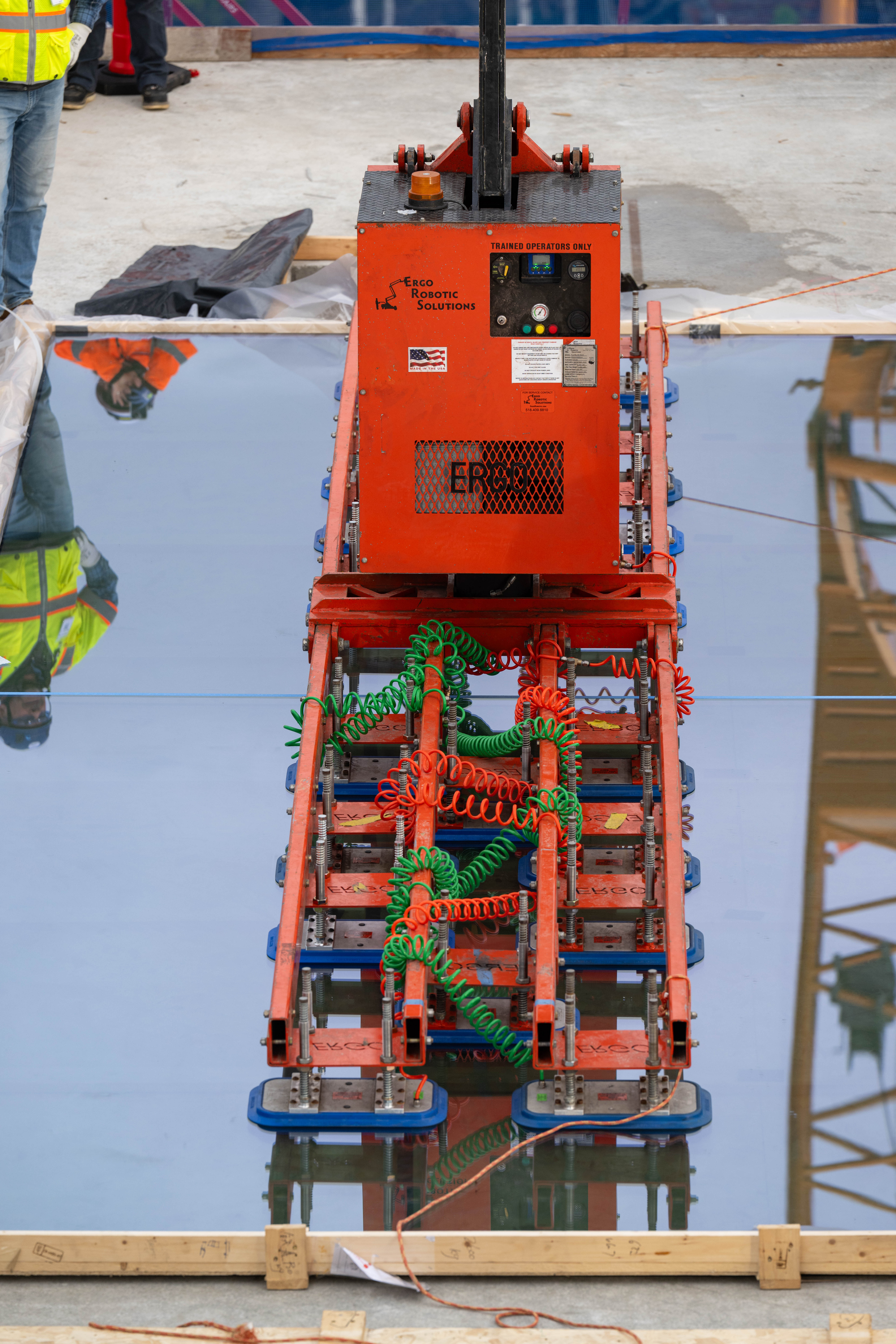 Close-up of a robotic vacuum lifter holding a glass panel.