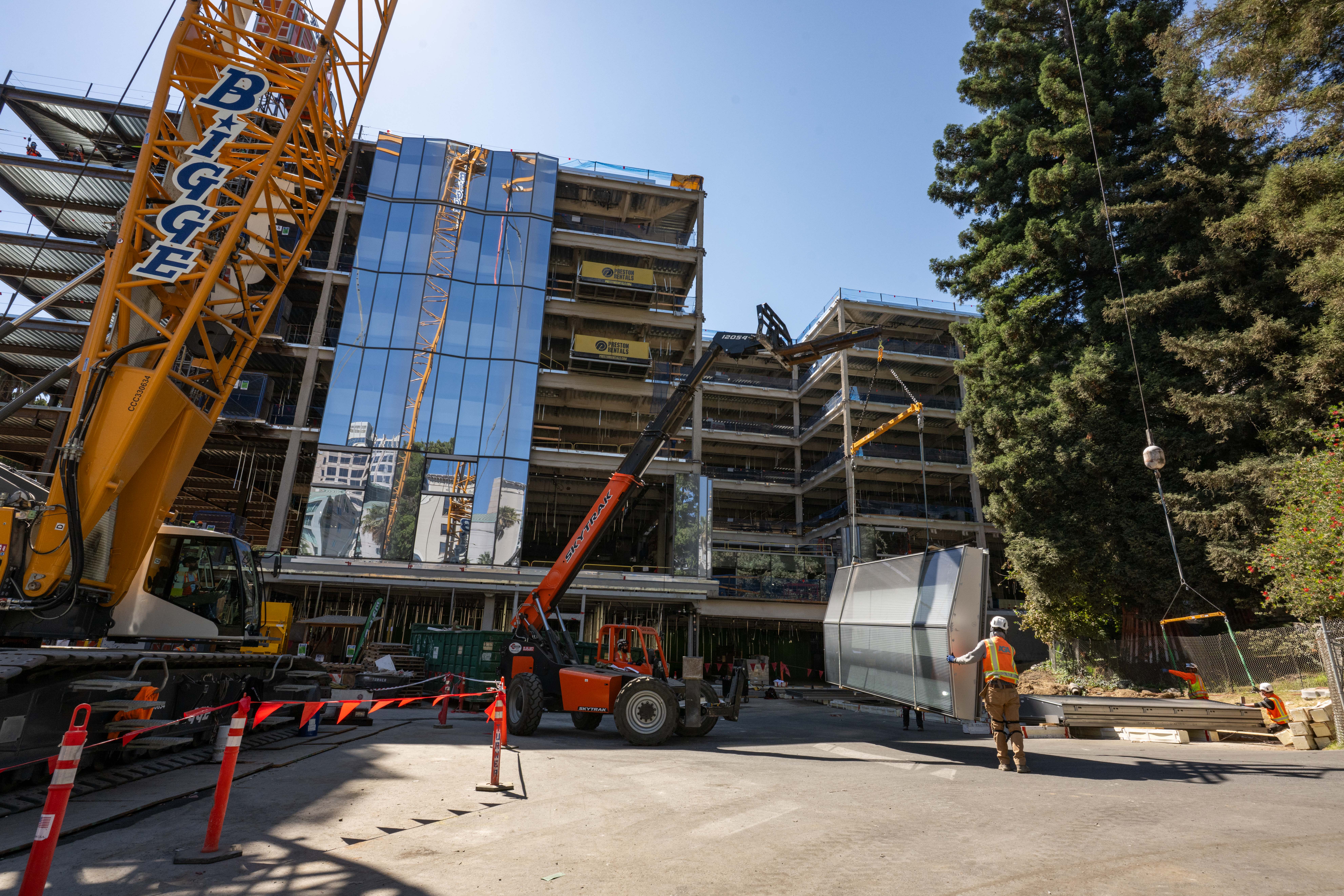 Construction site view with a crane and forklift moving materials.