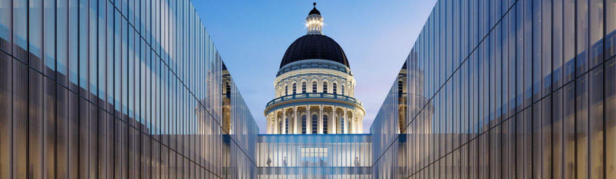 Symmetrical view looking between the new glass Annex walls towards the illuminated Capitol Dome at twilight.