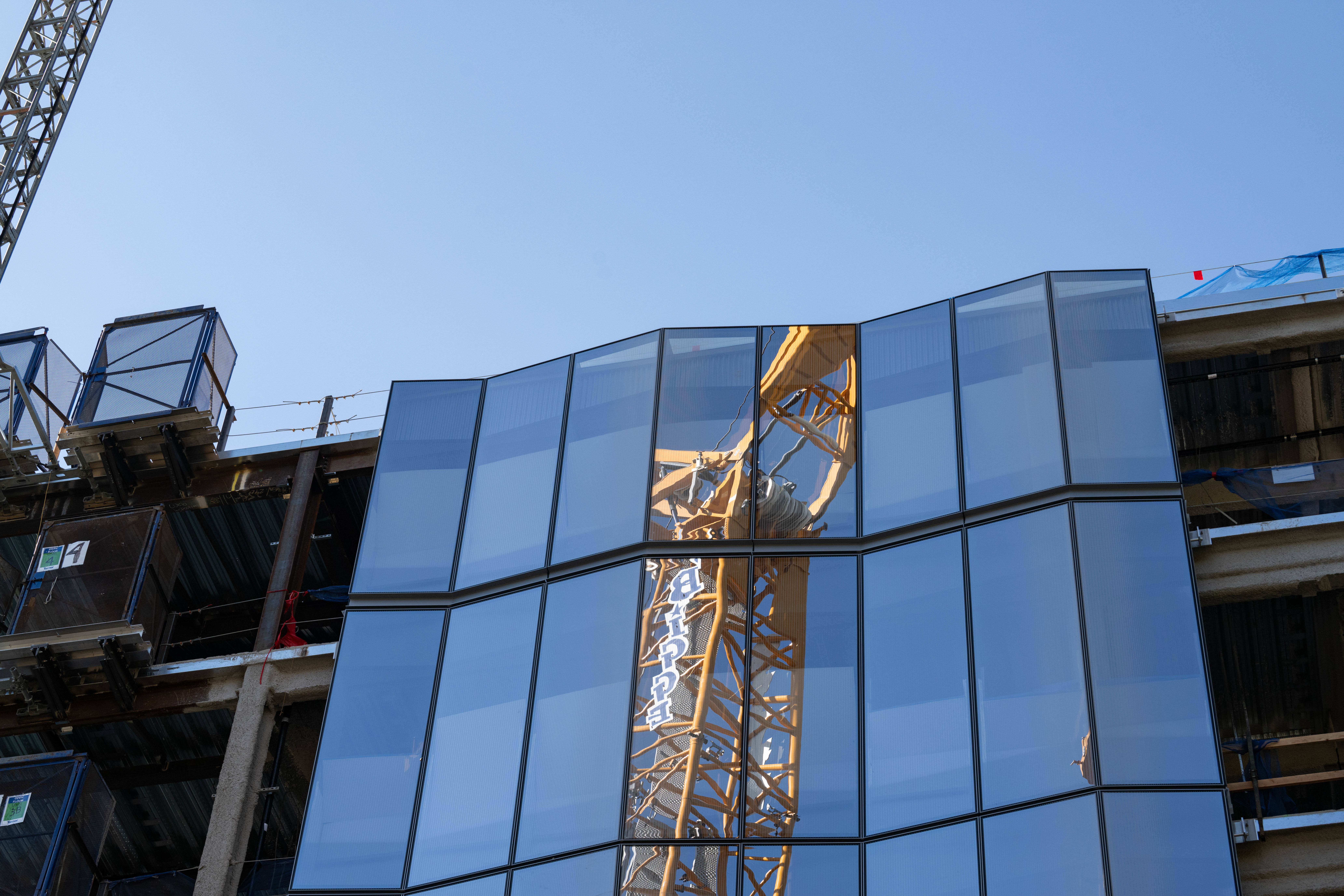 A crane is reflected in the façade glass.